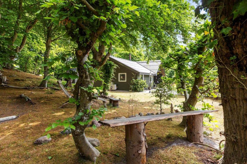 a wooden bench sitting in front of a house at 8881-Glesborg-Benzonstien-27 in Fjellerup Strand