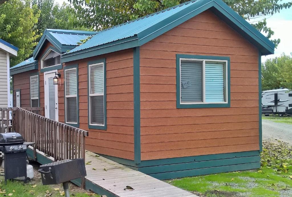 a tiny house with a blue roof at Lake Minden Camping Resort Cottage 1 in Nicolaus