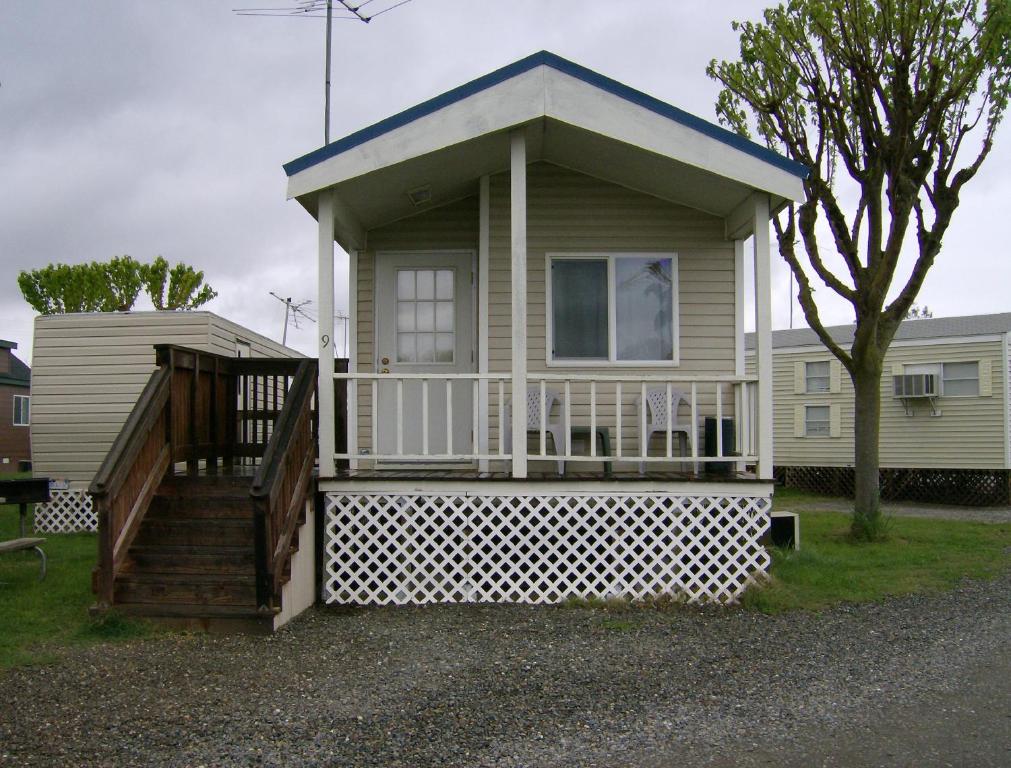 a small house with a porch and a staircase at Lake Minden Camping Resort Cabin 1 in Nicolaus