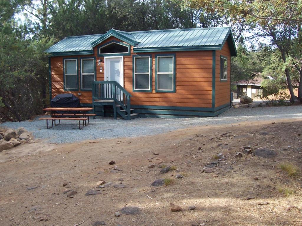 a log cabin with a bench and a table and a bench at Lake of the Springs Camping Resort Cabin 5 in Oregon House