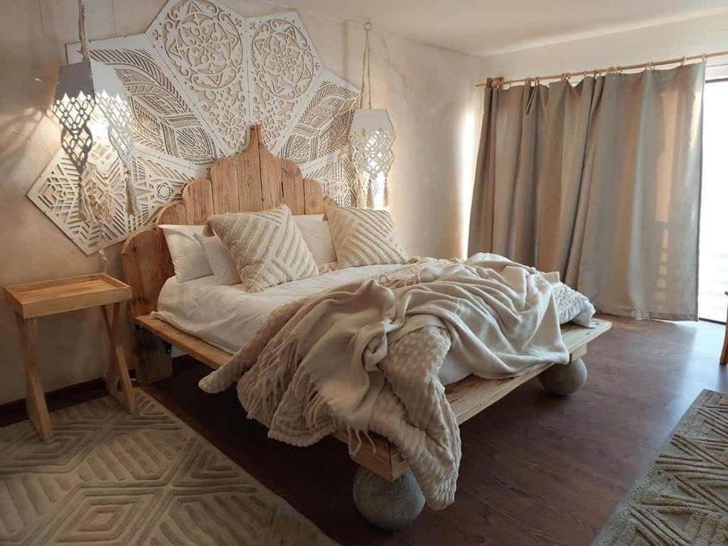 a bedroom with a large bed with a wooden headboard at Art Cabin Beach Villa in Langstrand