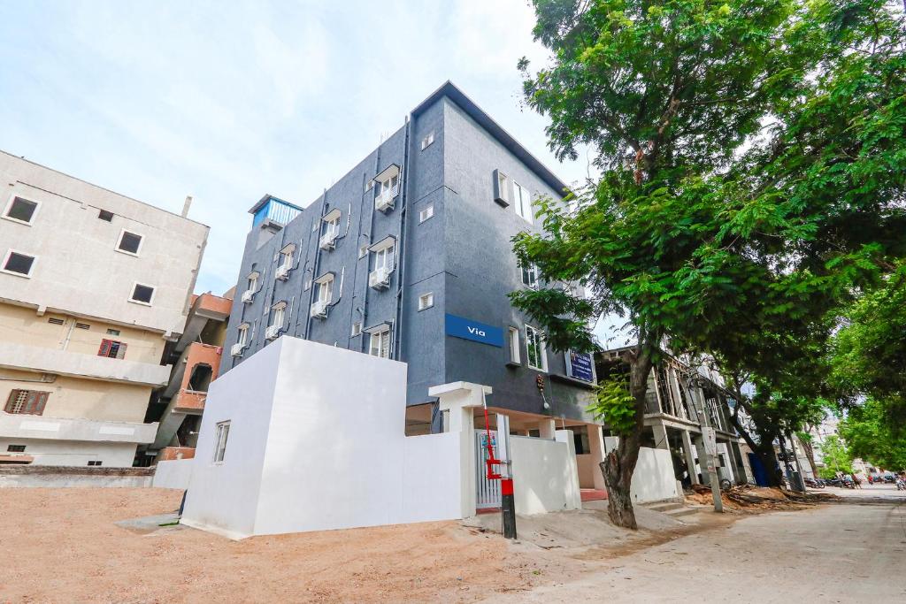 a blue building on a street next to a tree at Via Dream Connect - Narsingi in Hyderabad
