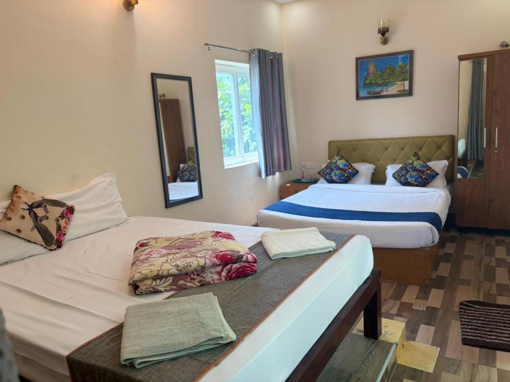 a bedroom with two beds and a mirror at Serenity Beach House in Pondicherry