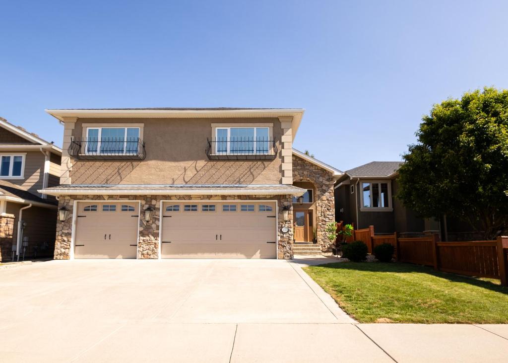 a house with two garage doors in a driveway at Opulent Oasis in Lethbridge