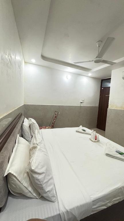 a large bed with white pillows in a room at Hotel M Palace Unit Of MDP Ayodhya Near Rammandir in Ayodhya