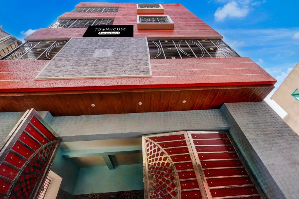 a tall red building with red doors on it at Townhouse Loknath Temple Road Puri Formerly Rashmi Villa in Puri