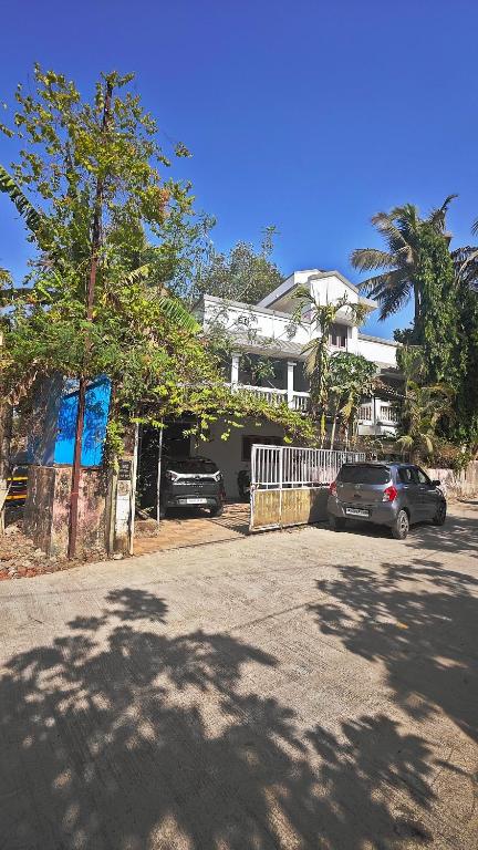 two cars parked in a parking lot in front of a house at Redwing Peaceful Studio in Navi Mumbai