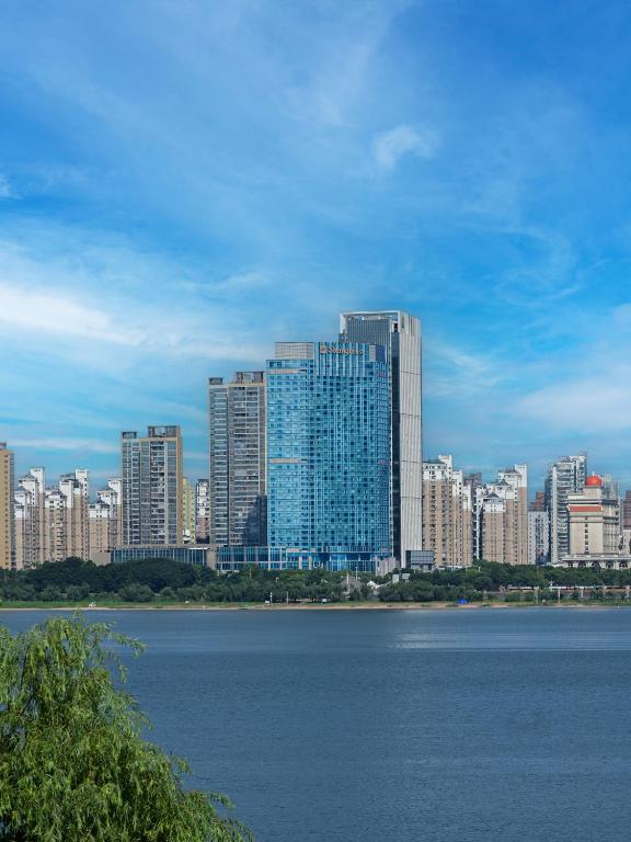 a city with tall buildings and a body of water at Shangri-La Nanchang丨Adjacent to Pavilion Prince Teng Prime river view in Nanchang