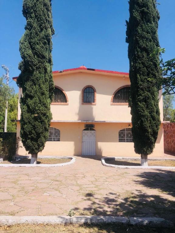 a house with two trees in front of it at Casa Jardín Santiago in Texcoco de Mora