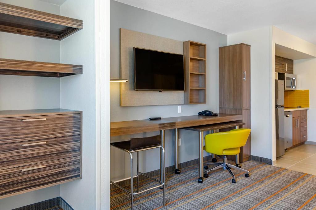 a hotel room with a desk and a yellow chair at MainStay Suites Great Falls Airport in Great Falls