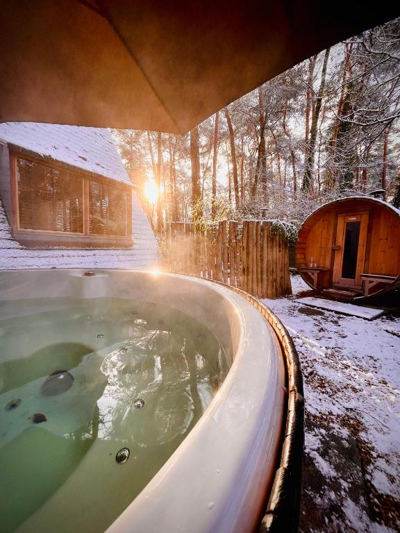 a bath tub in a yard with snow on the ground at Het Punthuisje in Lanaken