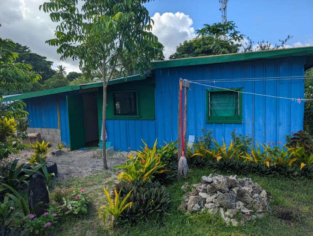 a blue house with a green roof at Lamkail beach island bungalow in Lénakel