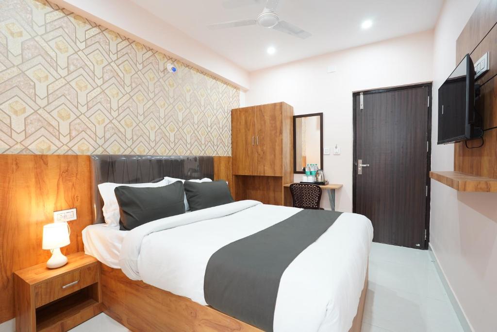 a bedroom with a large bed and a tv at Golden Comforts Banglore in Bangalore