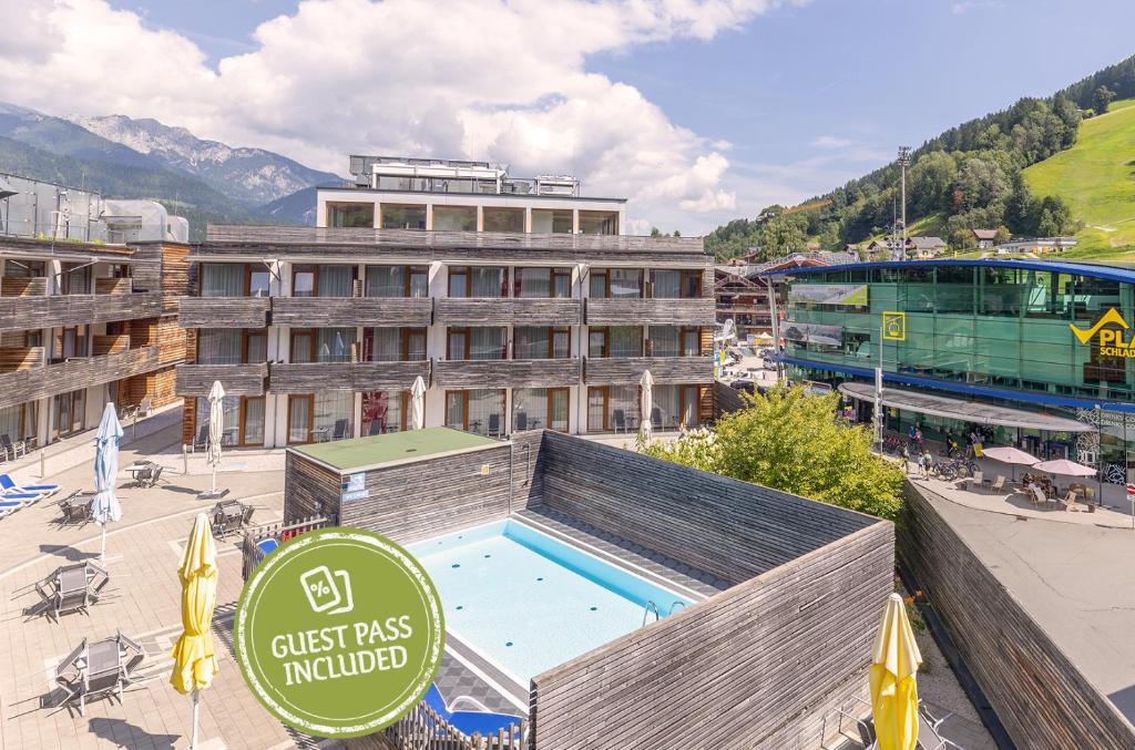 a hotel with a swimming pool in front of a building at Hotel Planai by Alpeffect Hotels in Schladming