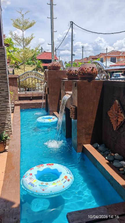 a pool with a water fountain in a backyard at Homestay Santai Bertam in Kepala Batas