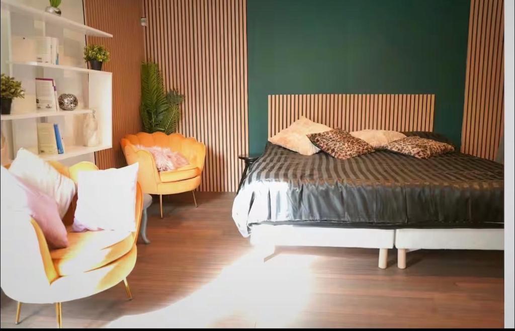 a bedroom with a bed and a couch and chairs at Nuit au Ranch Horse Paradise & Jacuzzi in Boutigny-sur-Essonnes