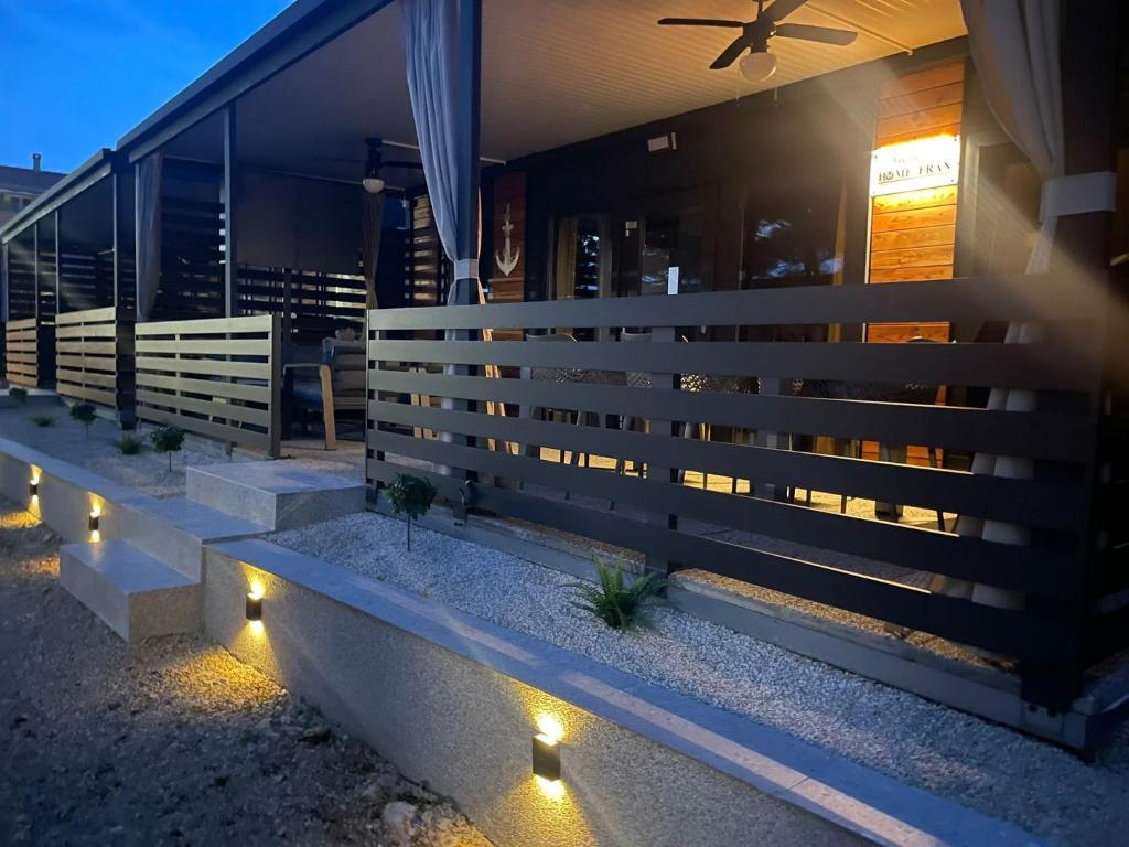a fence in front of a house with lights at Mobile Home River in Privlaka