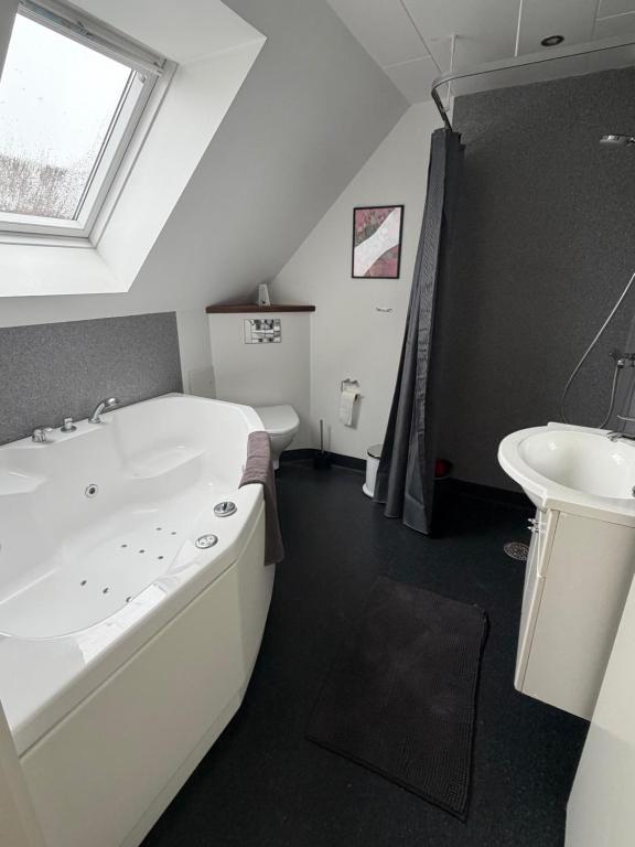 a bathroom with a bath tub and a sink at Kystvejen Øster Hurup in Hadsund