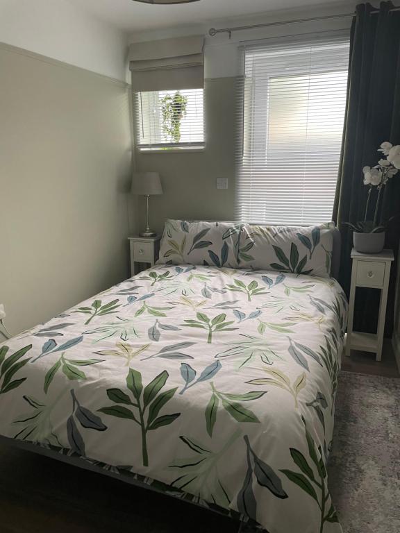 a bedroom with a bed with a floral bedspread at Oakwood in Fleet