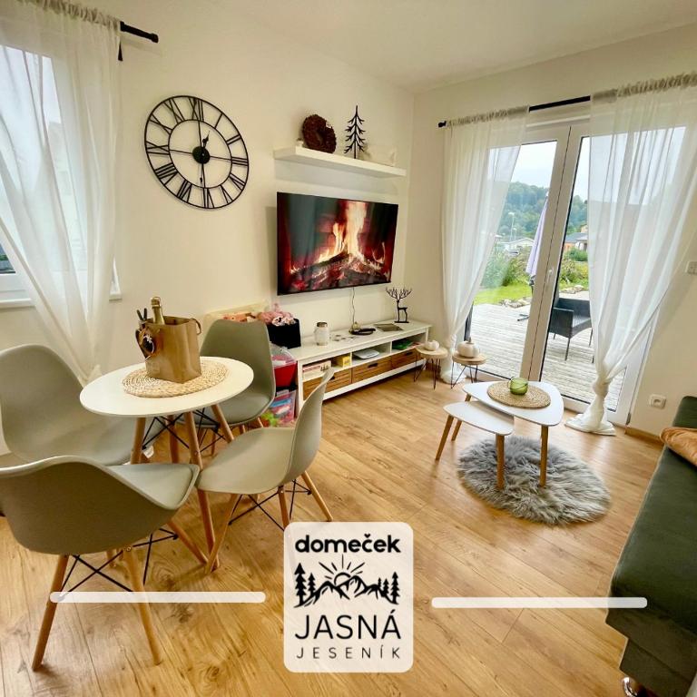 a living room with a tv and a table and chairs at Domeček Jasná in Jeseník