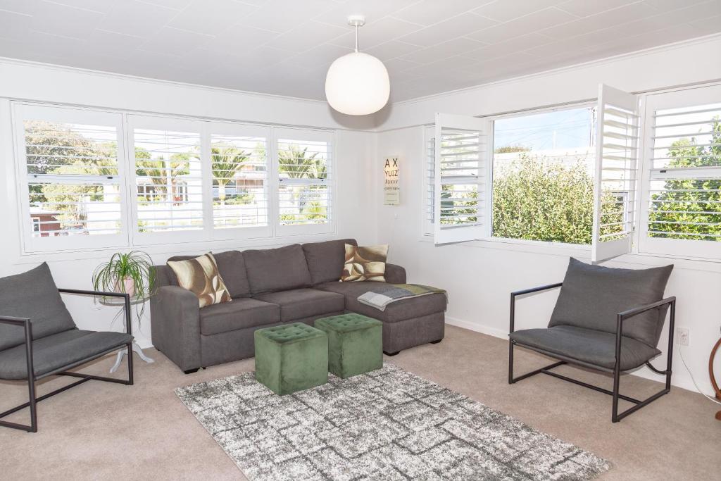 a living room with a couch and two chairs at Townhouse on Courtenay in New Plymouth
