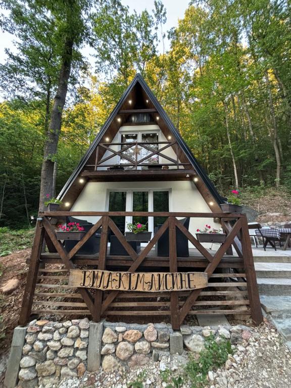 a small house with a sign in front of it at Planinska vila KTM Lisine in Despotovac