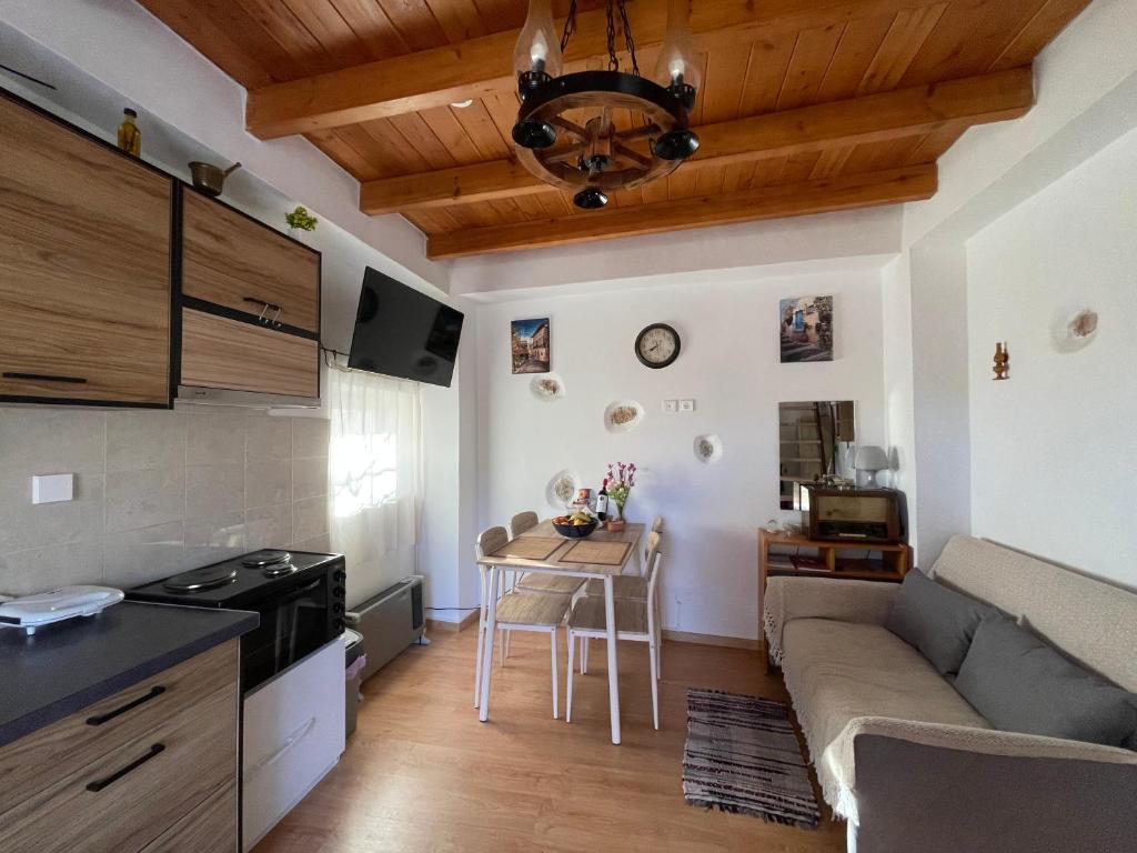 a kitchen and living room with a couch and a table at Tsitsinos maisonette house in Zekros