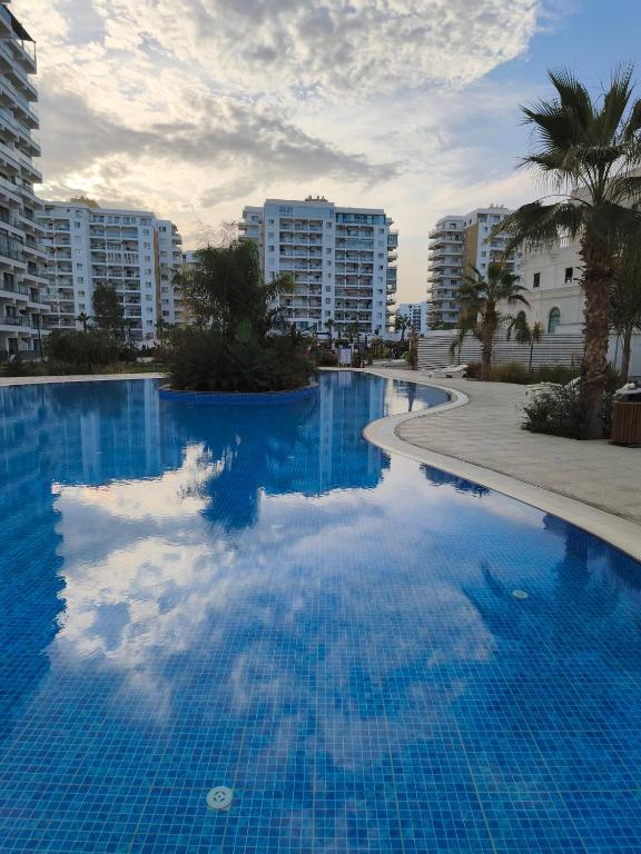 a large blue swimming pool with buildings in the background at Caesar Resort, Epictetus,Iskele, North Cyprus in Iskele