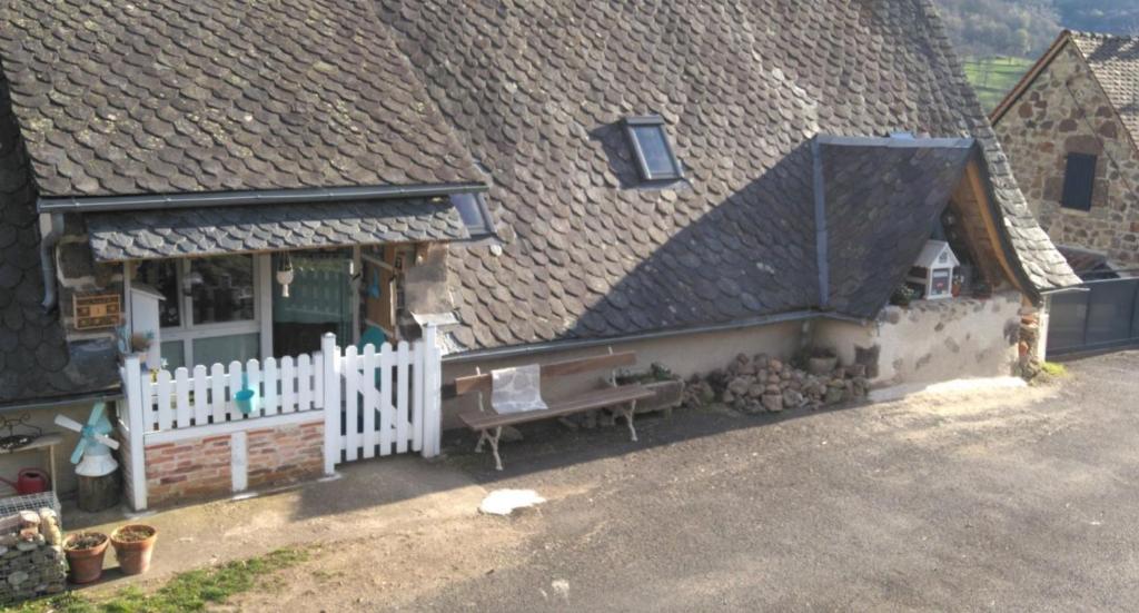 a house with a white fence and a bench outside at Gîte Shabby Blue in Saint-Cernin