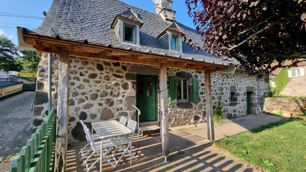 an old stone house with a chair in front of it at Gîte Rosa Bonheur in Saint-Cernin