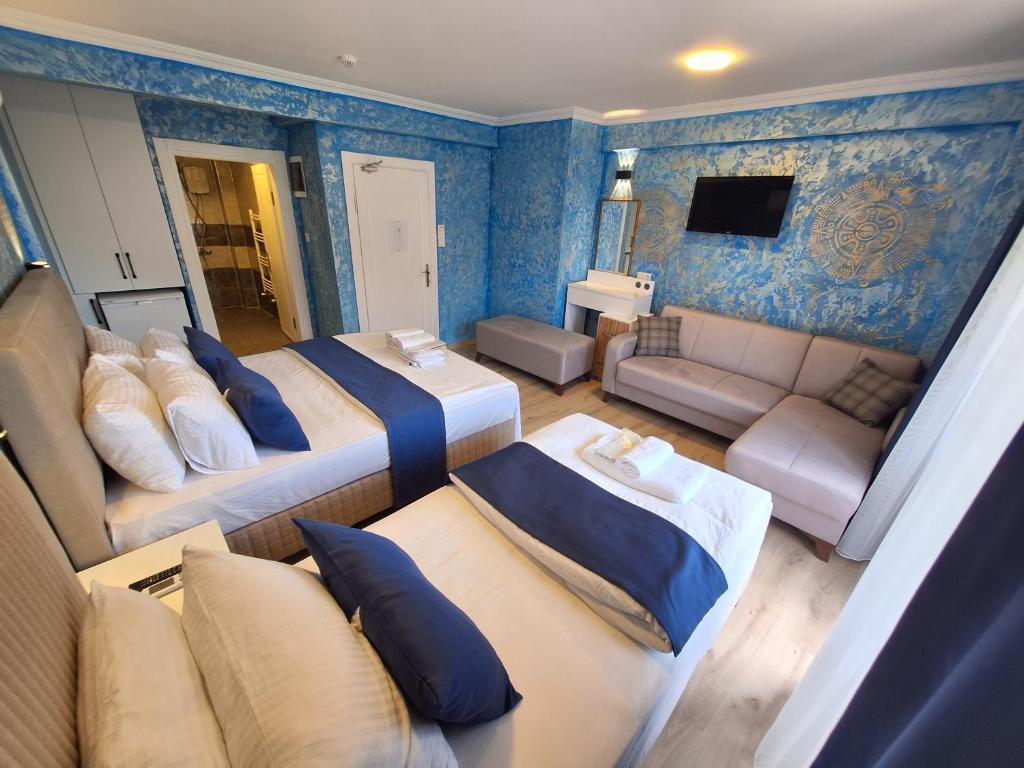 a hotel room with two beds and a couch at Dilmac Hotel in Gelibolu