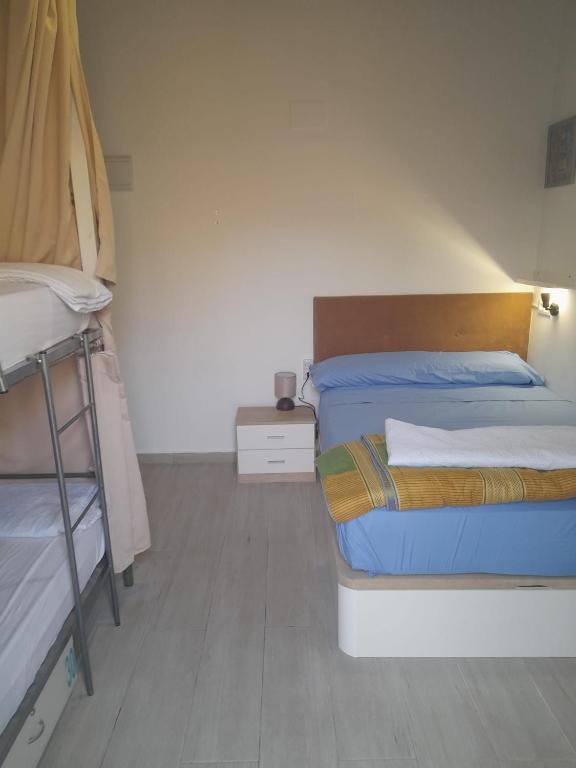 a bedroom with two beds and a night stand at HOSTEL PRIME in Benicàssim