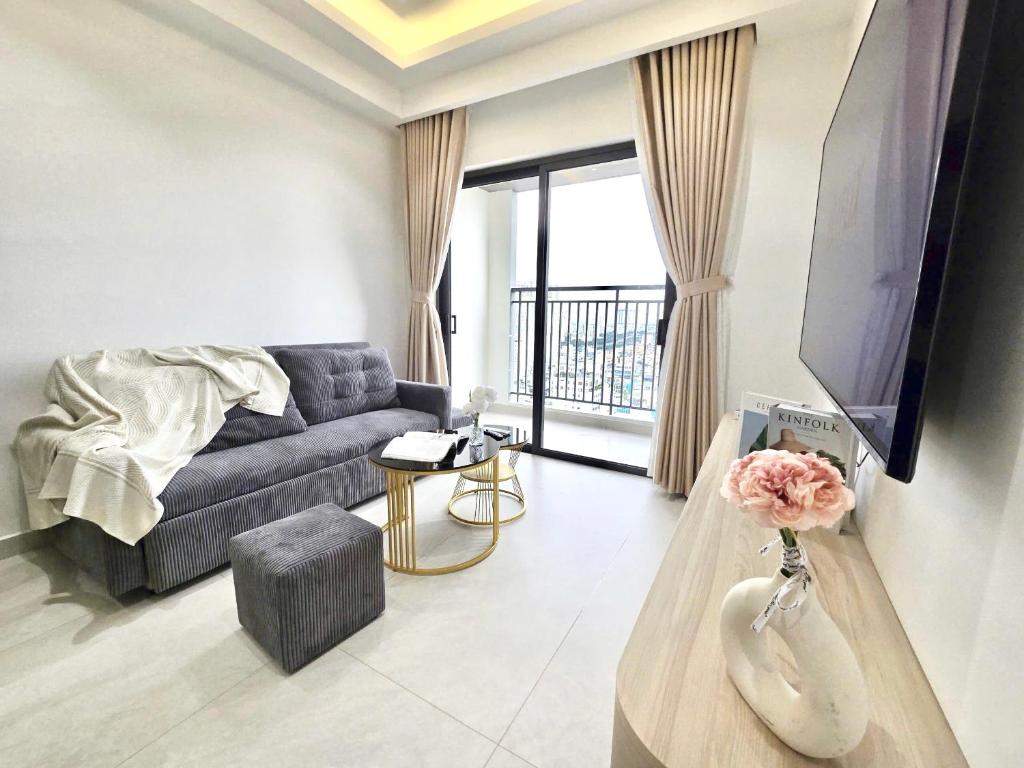a living room with a couch and a tv at Lloyd's Daily Suites - SOHO Residence, Bui Vien Walking Street, BenThanh Market & SG's Vibe in Ho Chi Minh City
