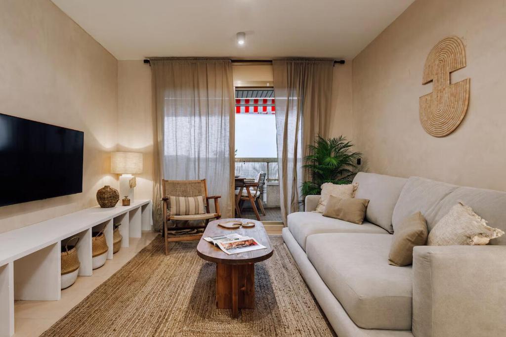 a living room with a white couch and a tv at Impressive beachfront home in Calafell