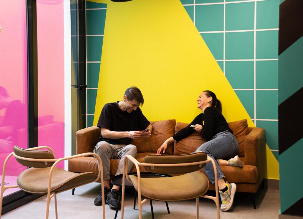 a man and a woman sitting on a couch at Funker Hostel in Málaga