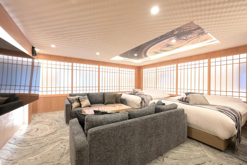 a living room with a couch and a bed at HOTELみなと-Minato- 新宿 in Tokyo