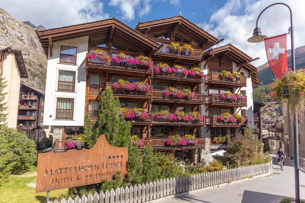 a building with flower boxes on the side of it at Matterhorn Lodge Boutique Hotel & Apartments in Zermatt