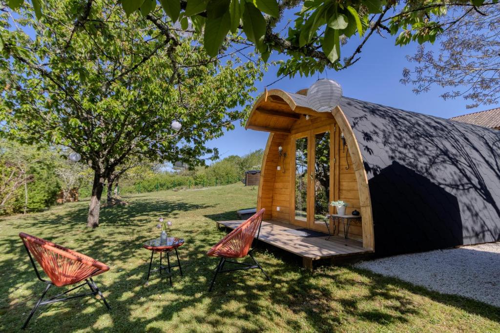 a tent with a table and chairs in a yard at Chambre d'Hôtes La Guignette in Saint-Cybranet