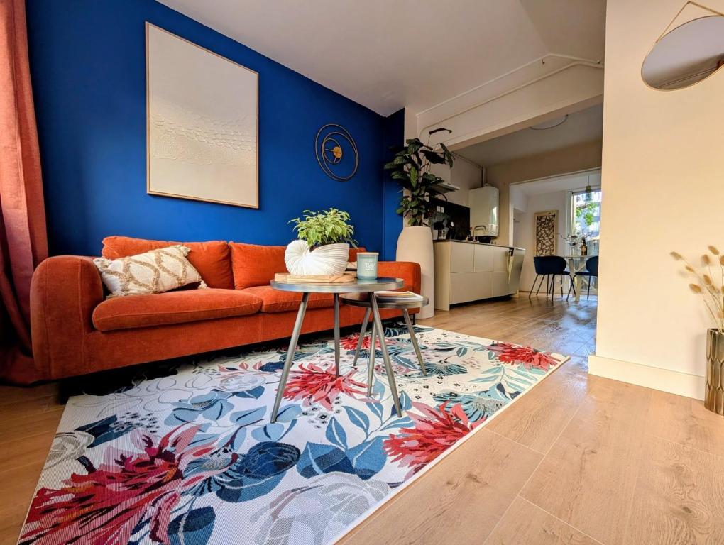 a living room with an orange couch and a blue wall at Ma Casa in Boulogne-sur-Mer