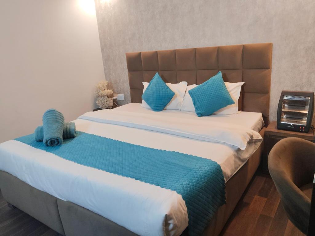 a bedroom with a large bed with blue pillows at Tara Luxury Homes in Solan