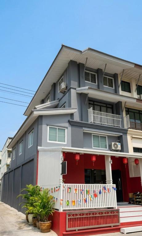a building with a red and white fence in front of it at Hugg daily airport 1 in Samutprakarn