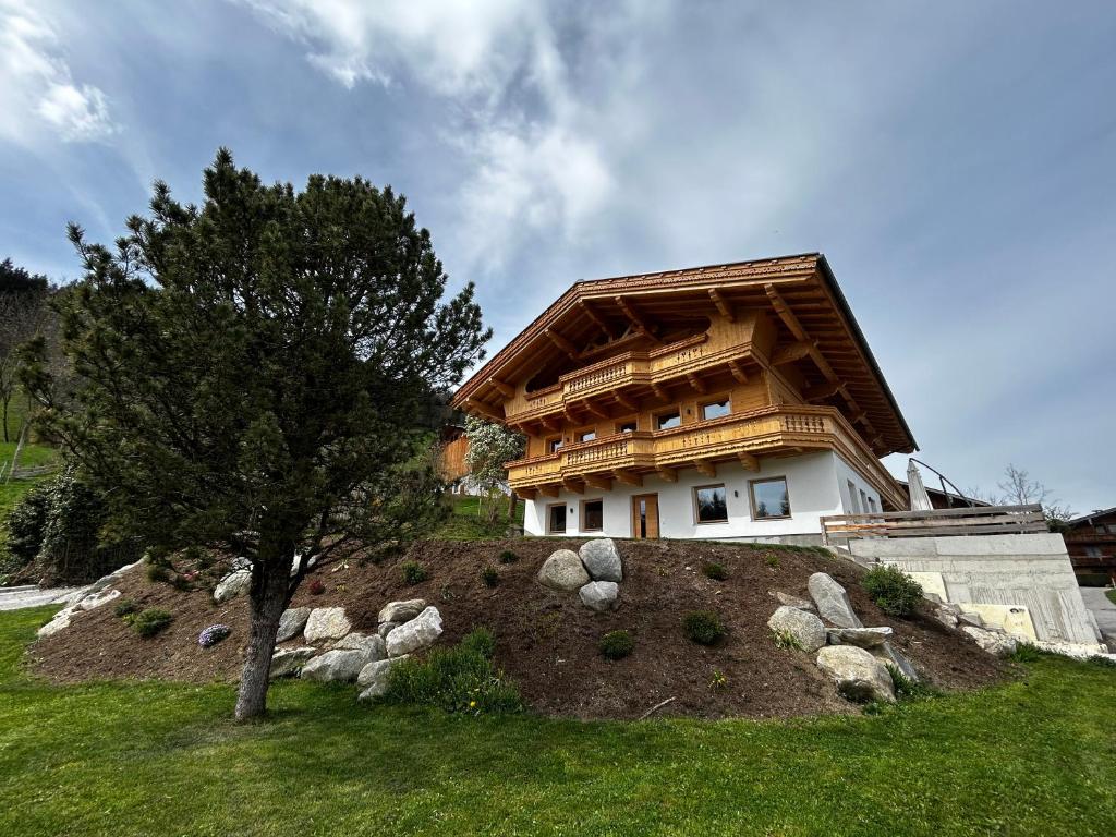 a house on top of a hill with a tree at Wiererhof in Fügenberg
