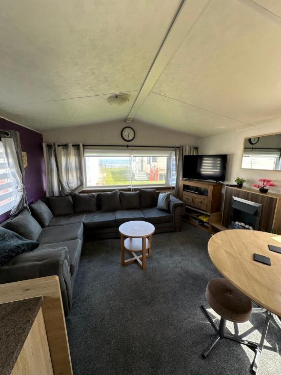 a living room with a couch and a table at Seaside views in North Seaton