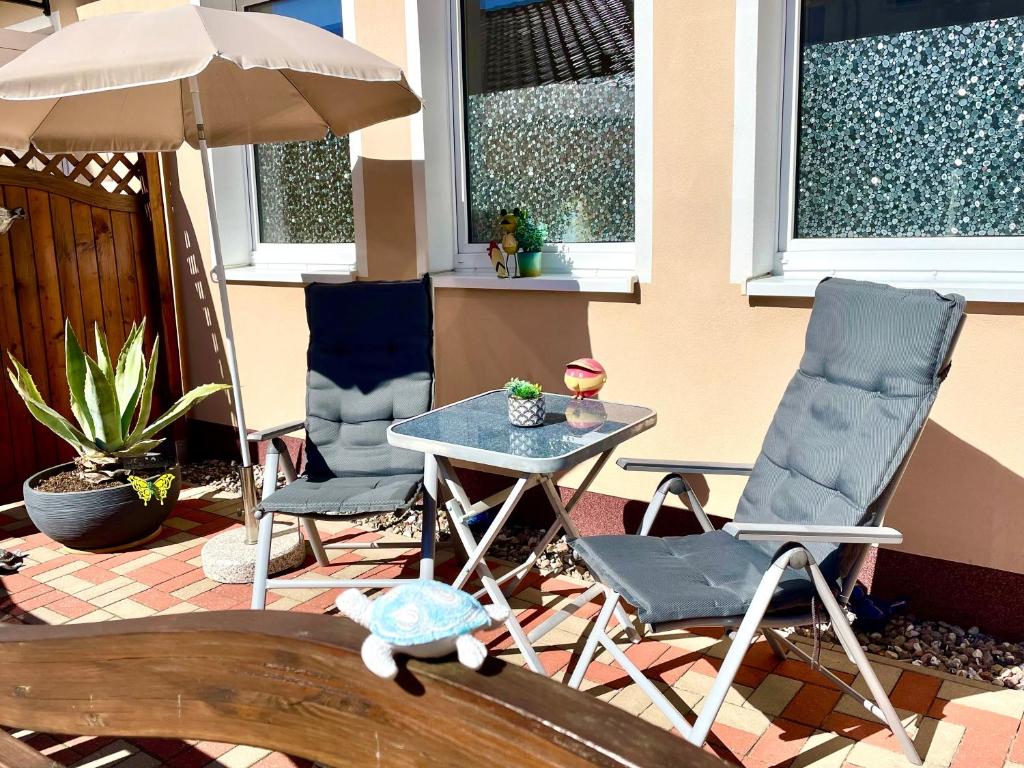 a patio with two chairs and a table and an umbrella at Ferienwohnung in der Seestraße in Sassnitz