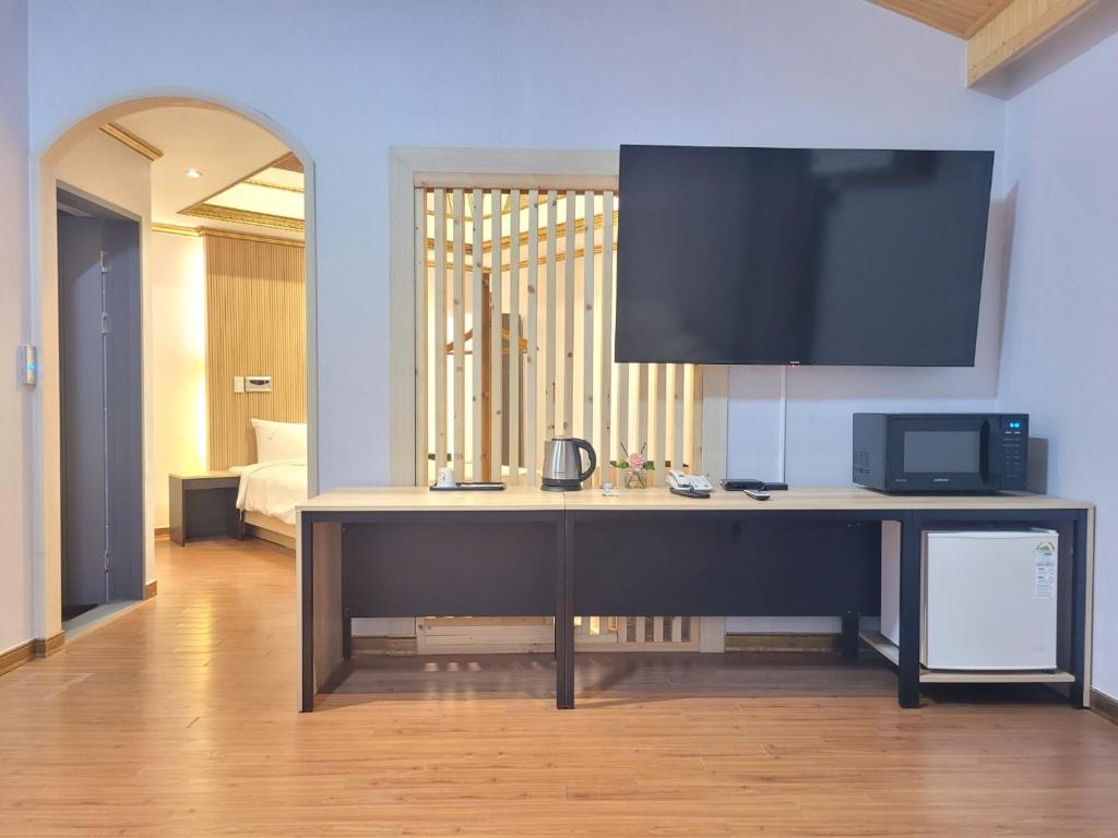 a room with a desk with a tv on the wall at 호텔야자 담양점 신관 in Kasan-ni
