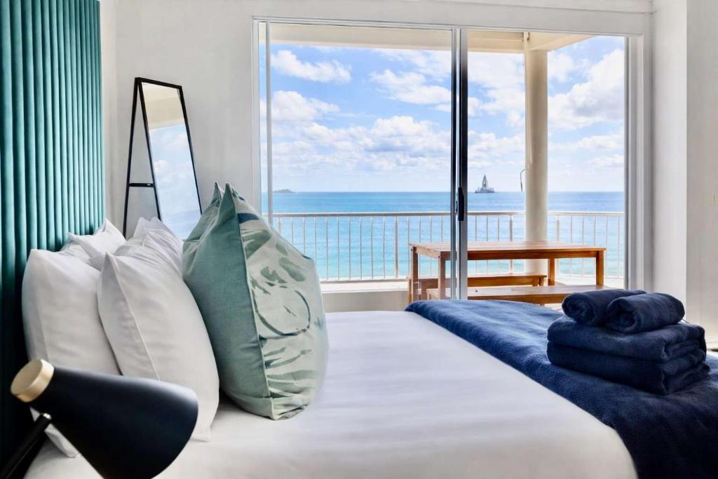 a bedroom with a bed with a view of the ocean at Sunset View 23 in Langstrand