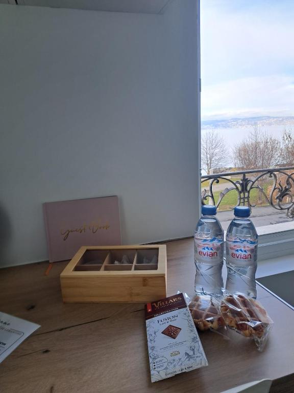 two bottles of water and a box on a table at La Parenthèse Lémantine - Studio 3 in Neuvecelle