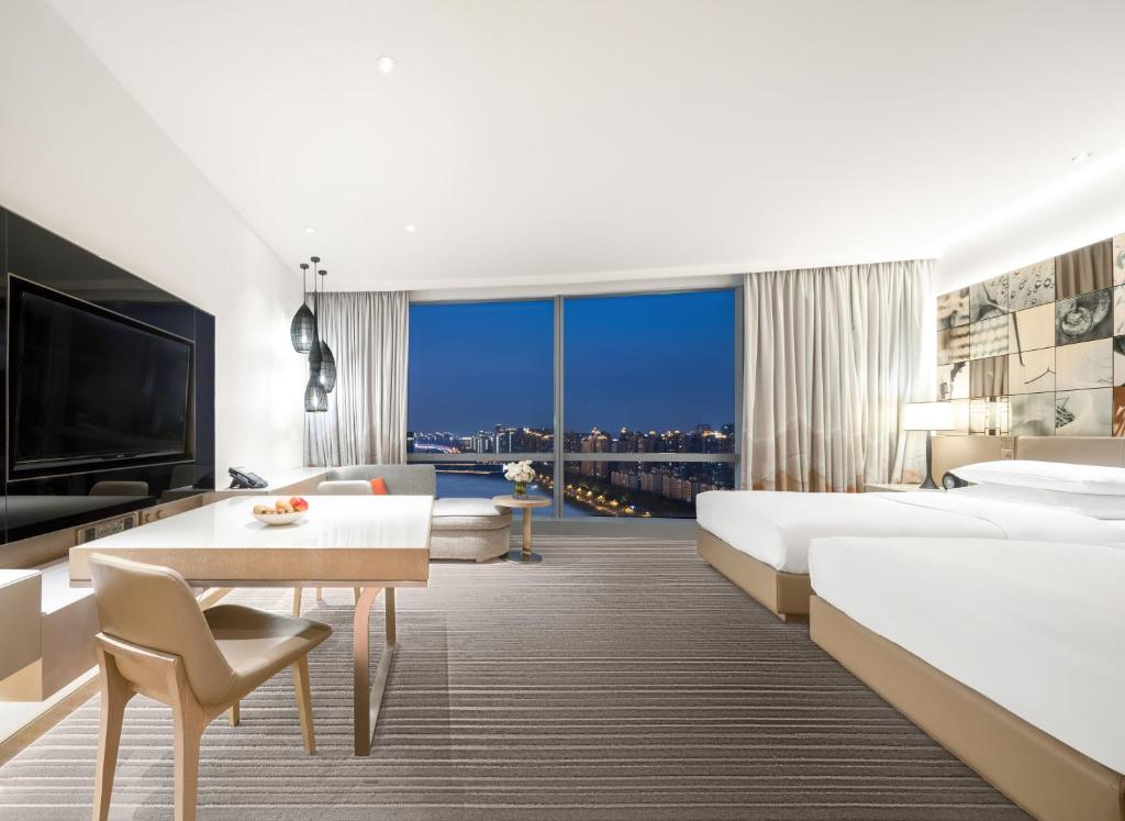 a hotel room with two beds and a large window at Hyatt Regency Suzhou in Suzhou
