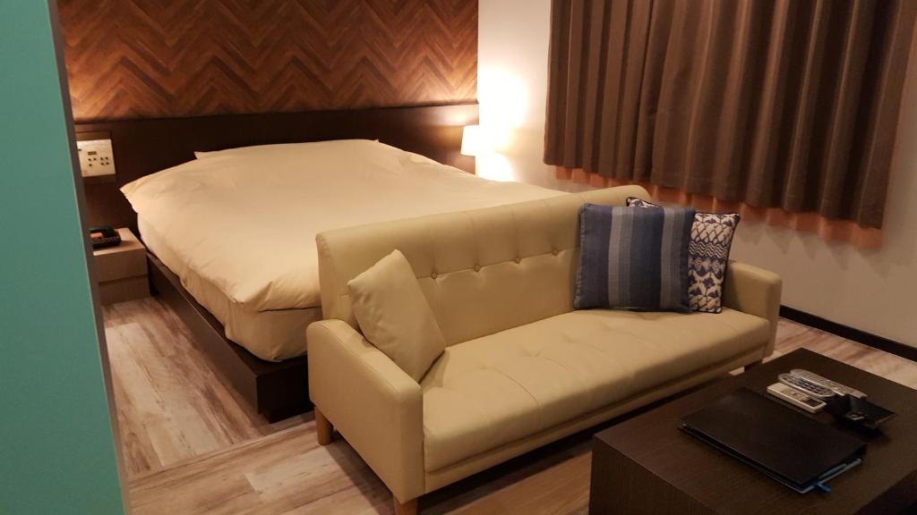 a living room with a bed and a couch at ホテルピュアゲート in Isesaki