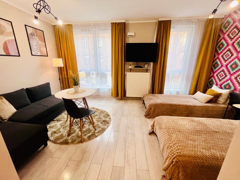 a living room with a couch and a table at Apartamenty Brzeska 10 in Warsaw